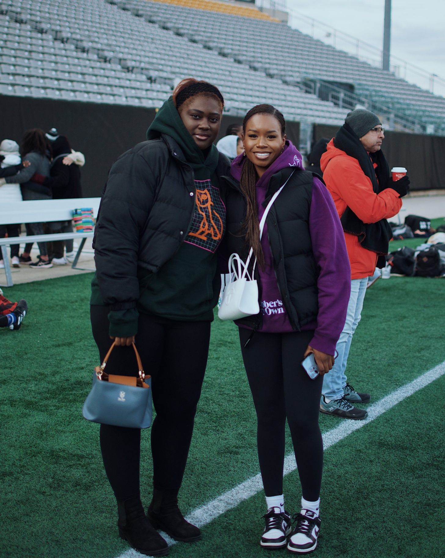 Two friends posing on the sideline after the game