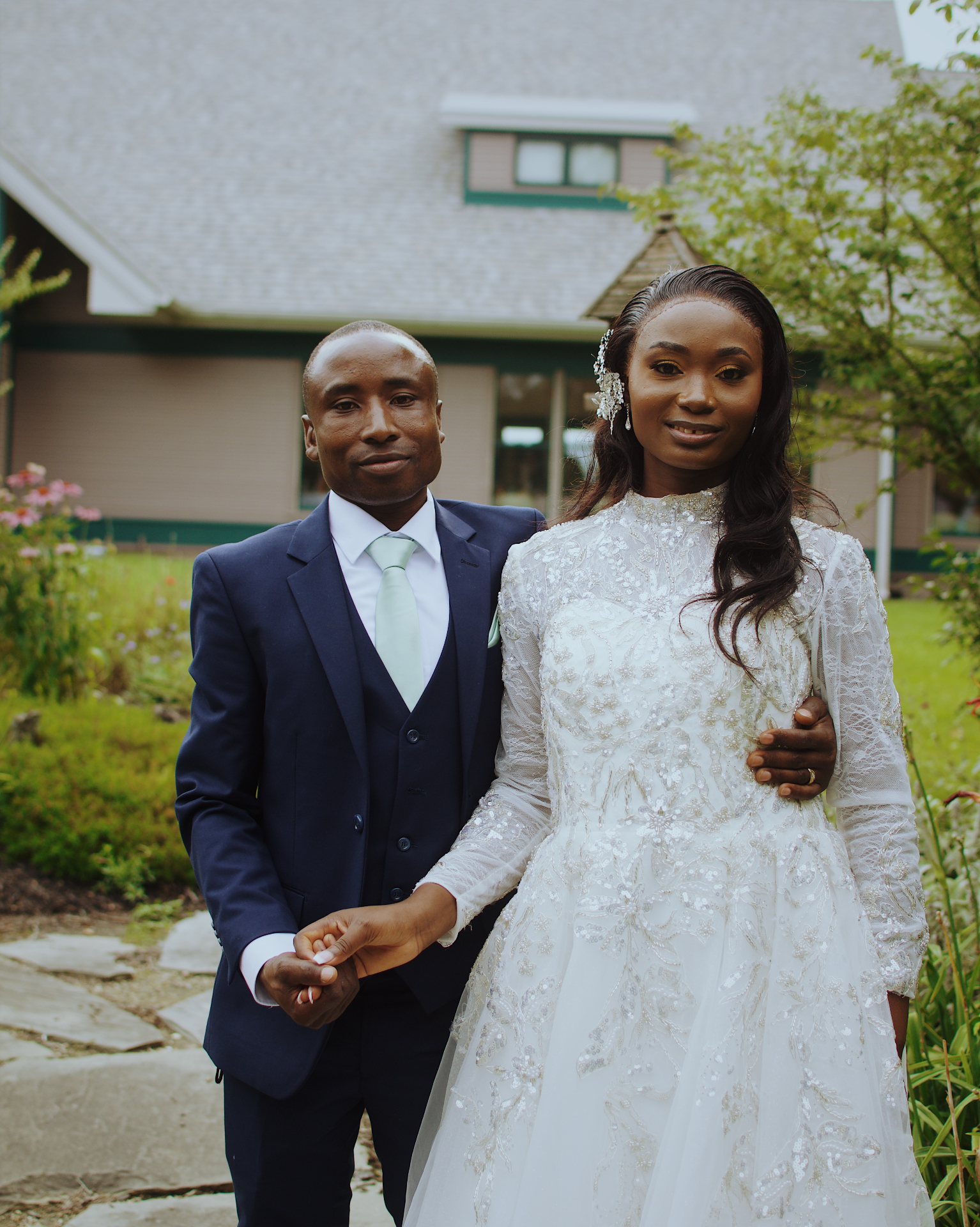 Bride and groom holding hands outside the venue garden