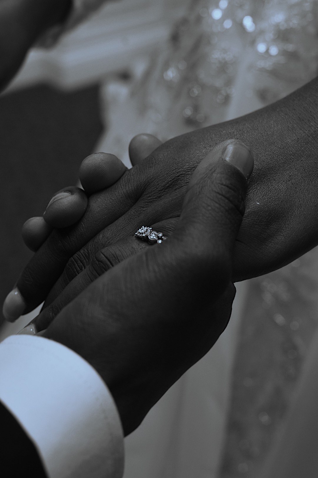 Wedding ring detail, hands held in black and white