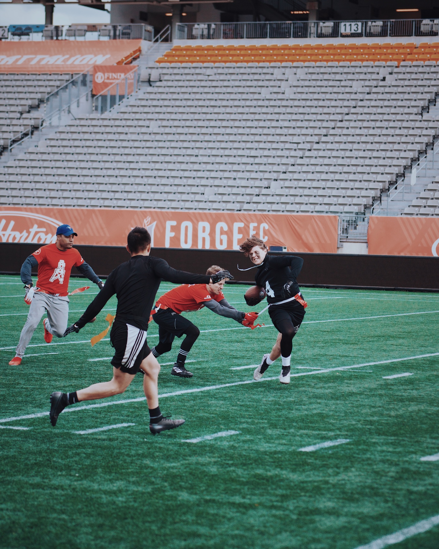 Ball carrier breaking a flag pull in front of the Forge FC boards