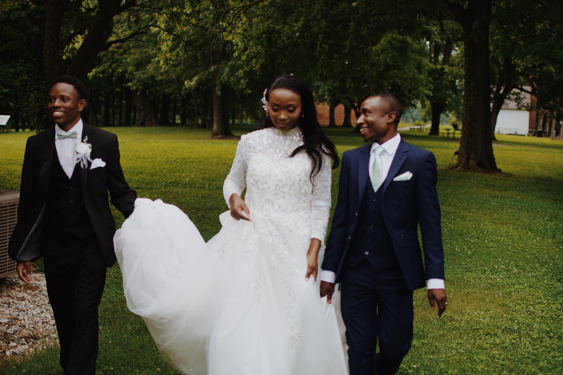 Bride walking with groomsmen through the park