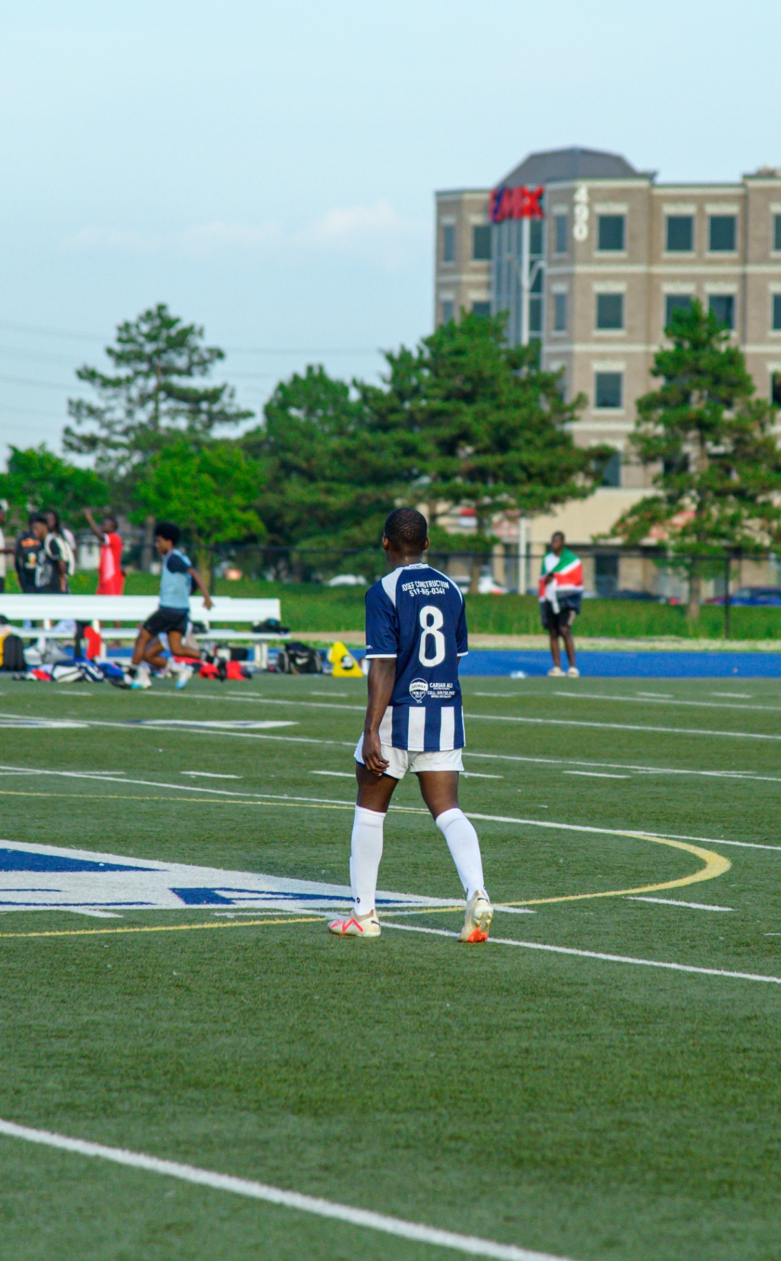 Midfielder #8 walking to position with the RE/MAX building behind