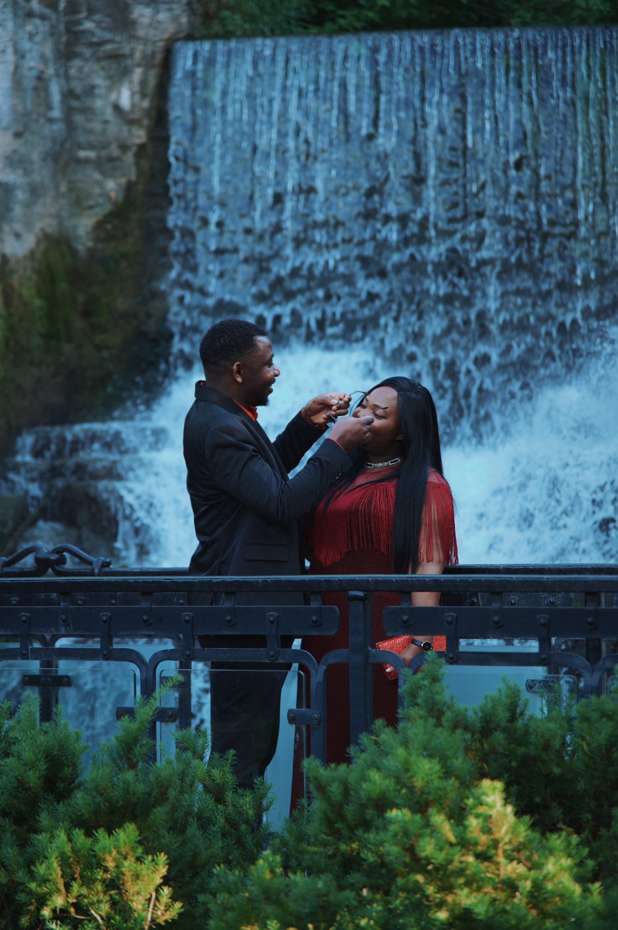 Tender moment on the bridge in front of the falls