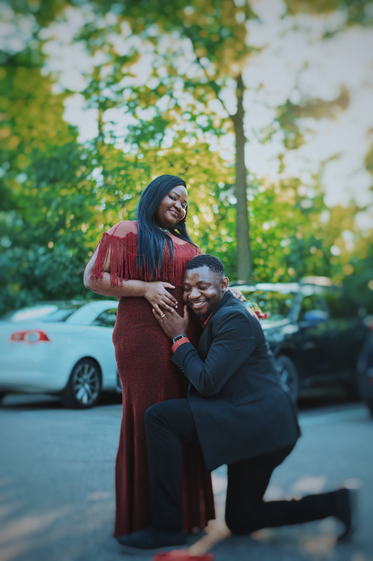 Proposal on one knee in a red gown and black suit